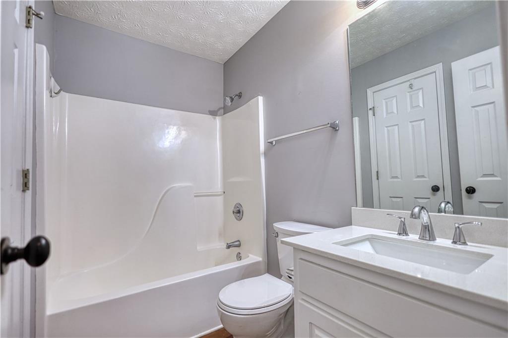 1006 English Oak Lane Winder, GA 30680 - Photo 36 of 83 a bathroom with a sink a toilet and a large mirror