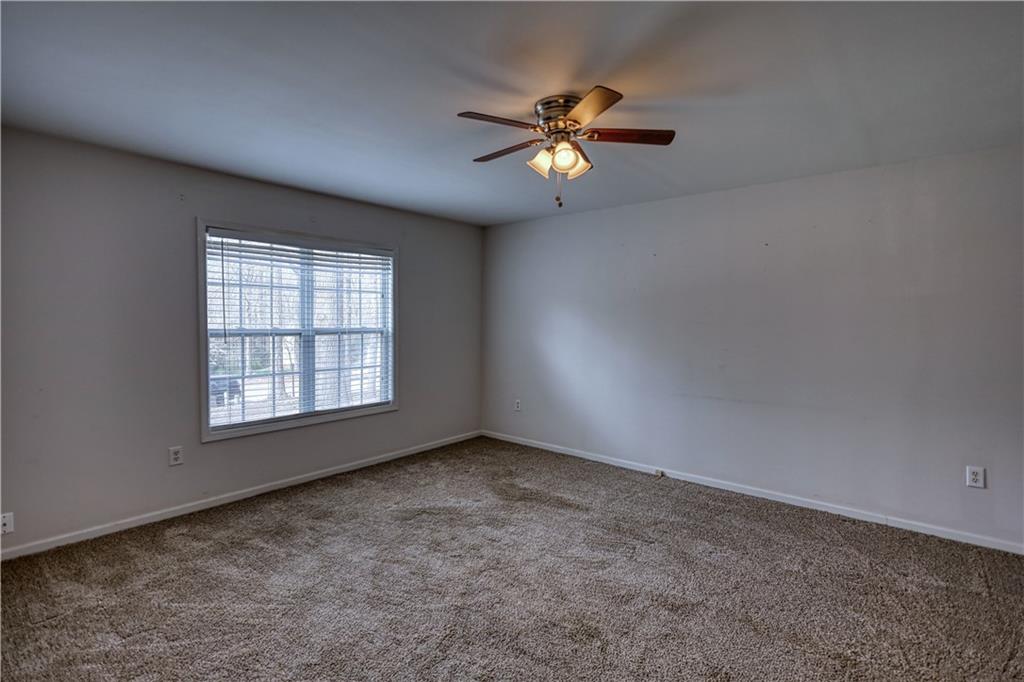 1006 English Oak Lane Winder, GA 30680 - Photo 44 of 83 an empty room with windows and chandelier fan