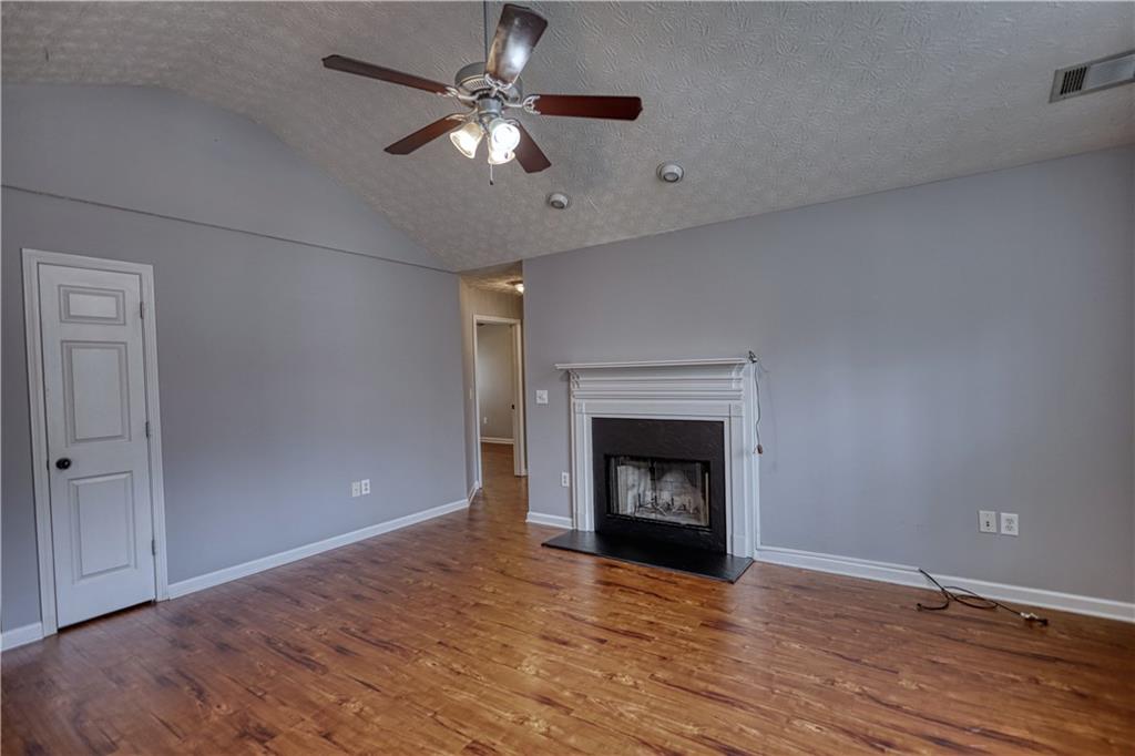 1006 English Oak Lane Winder, GA 30680 - Photo 7 of 83 a view of an empty room with wooden floor fireplace and a window