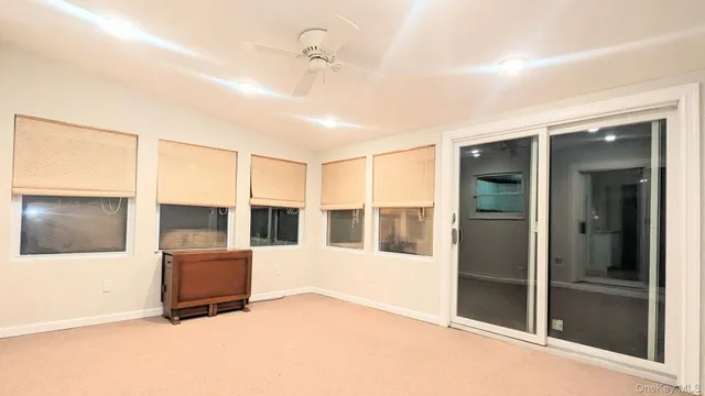 a living room with a large window and chandelier