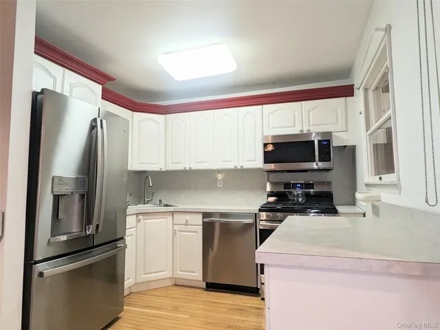 a kitchen with a sink a microwave a refrigerator and cabinets