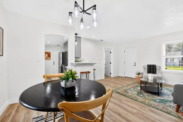 a living room with furniture kitchen view and a potted plant
