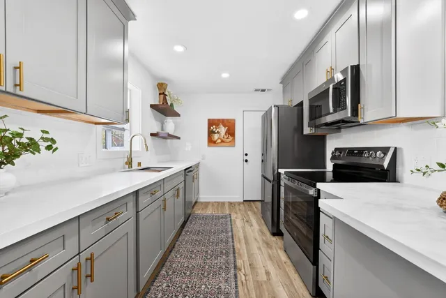 a kitchen with stainless steel appliances a sink stove and refrigerator