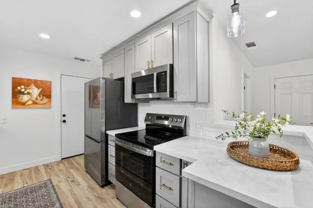 a kitchen with stainless steel appliances granite countertop a sink stove and refrigerator