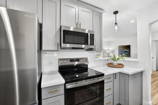 a kitchen with stainless steel appliances a stove microwave and a refrigerator