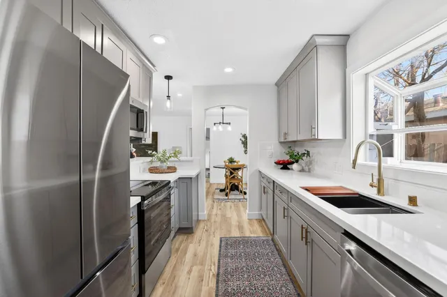 a kitchen with stainless steel appliances granite countertop a sink stove and refrigerator