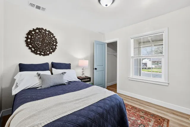 a bedroom with a bed and a painting on the wall