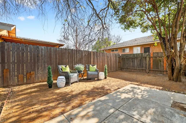 a view of backyard with a table and chairs and a large tree