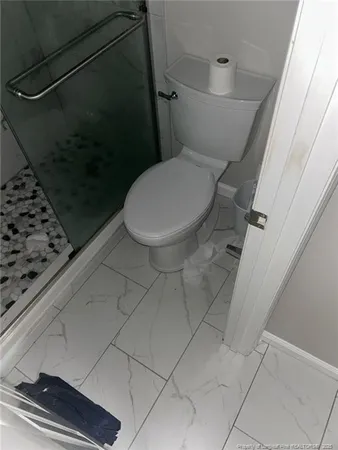a bathroom with a toilet and a shower