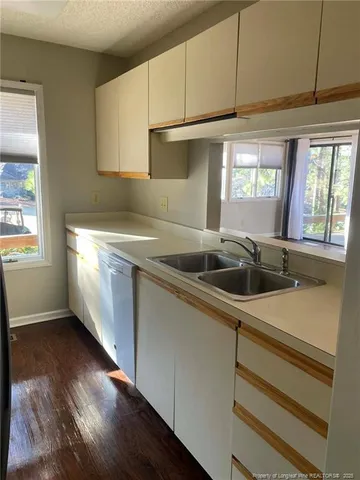 a kitchen with granite countertop a sink stainless steel appliances and cabinets