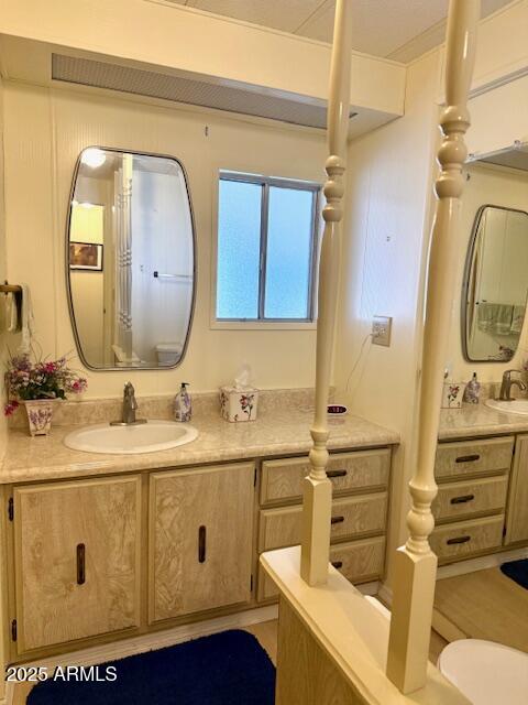 2605 South Tomahawk Road, Unit 46 Apache Junction, AZ 85119 - Photo 28 of 47 a bathroom with a granite countertop toilet sink and mirror