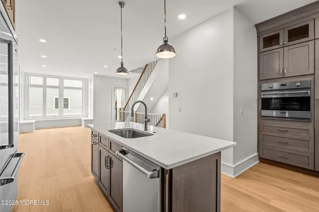 a kitchen that has a sink a stove and a wooden floor