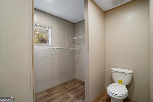 a white toilet sitting next to a window