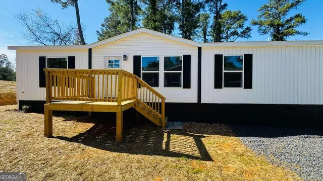 a view of house with backyard outdoor seating and deck