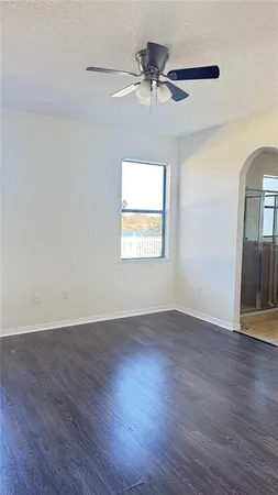 a view of an empty room with wooden floor