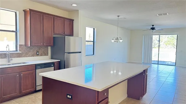 a kitchen with kitchen island a sink dishwasher a stove and a refrigerator with wooden cabinets