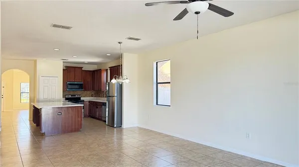 a kitchen with stainless steel appliances granite countertop a refrigerator a stove a sink and a microwave