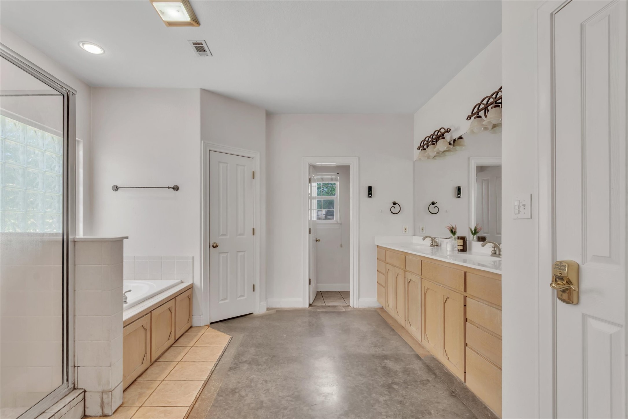 1120 Meadow Ridge Drive Austin, TX 78737 - Photo 18 of 40 A well-lit primary bathroom featuring a spacious vanity with dual sinks and a large soaking tub.