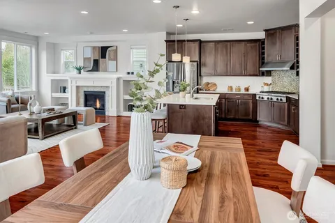 a living room with furniture fireplace and kitchen view