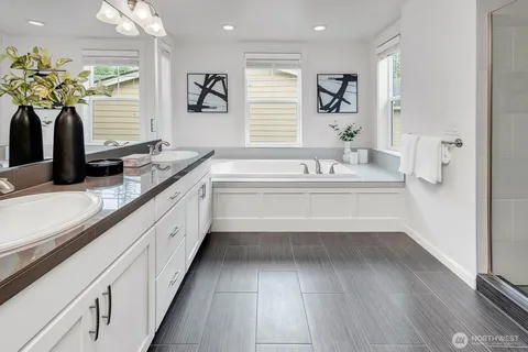 a bathroom with a tub sink and mirror