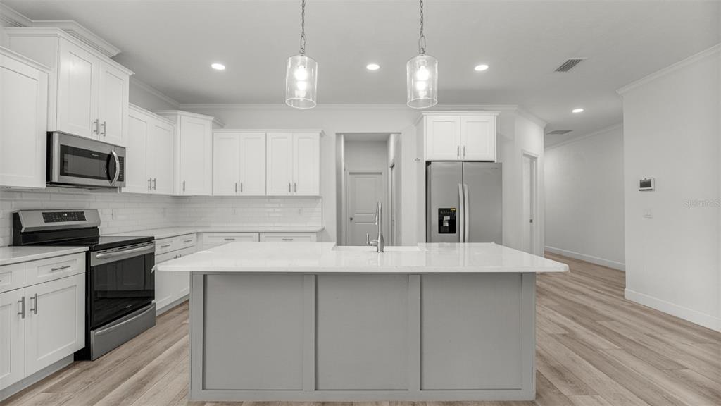 6657 Southwest 15 Place Gainesville, FL 32607 - Photo 5 of 26 a large kitchen with stainless steel appliances granite countertop a stove a sink and a refrigerator