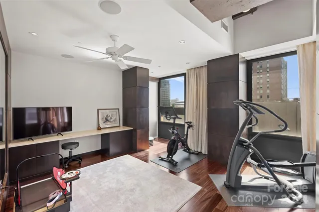 a view of a workspace with furniture and a gym machine