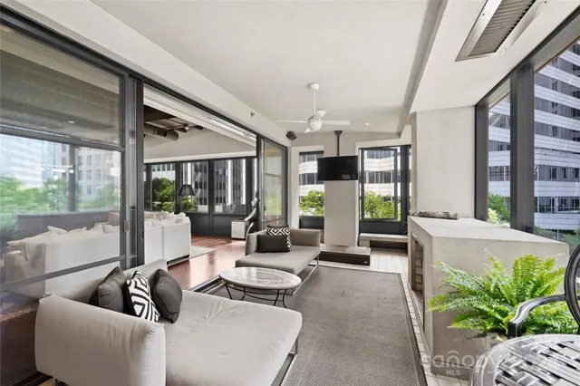 a living room with furniture potted plant and a large window