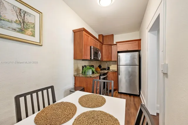 a kitchen with a refrigerator a stove top oven a sink and a window