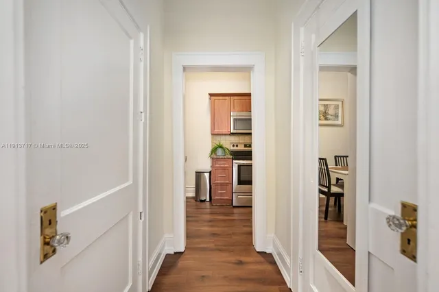 a view of a hallway with wooden floor and a living room