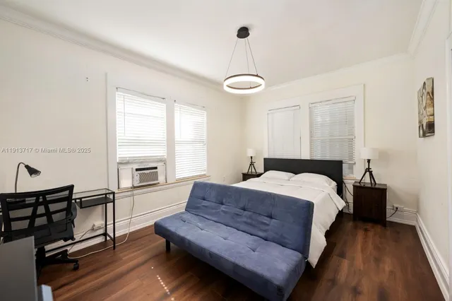 a bedroom with a bed and a dresser next to a window
