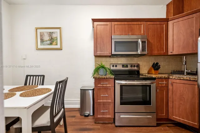 a kitchen with stainless steel appliances granite countertop a stove a microwave a sink and cabinets