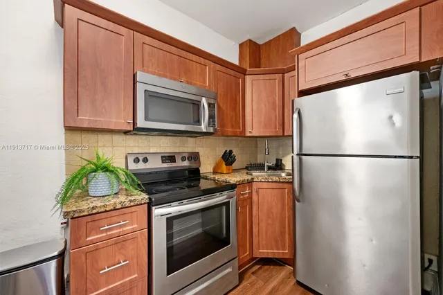 a kitchen with stainless steel appliances granite countertop a refrigerator stove and microwave
