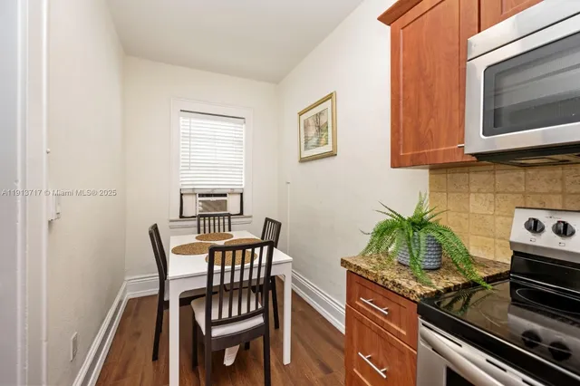 a kitchen with stainless steel appliances a stove a table and chairs