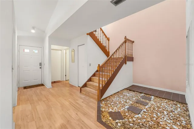 a view of a hallway with wooden floor and staircase