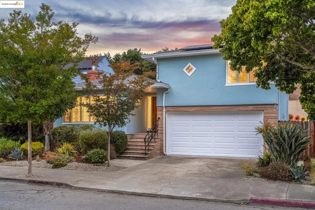 a front view of a house with a tree
