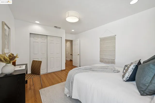 a bedroom with two large bed and a wooden floor
