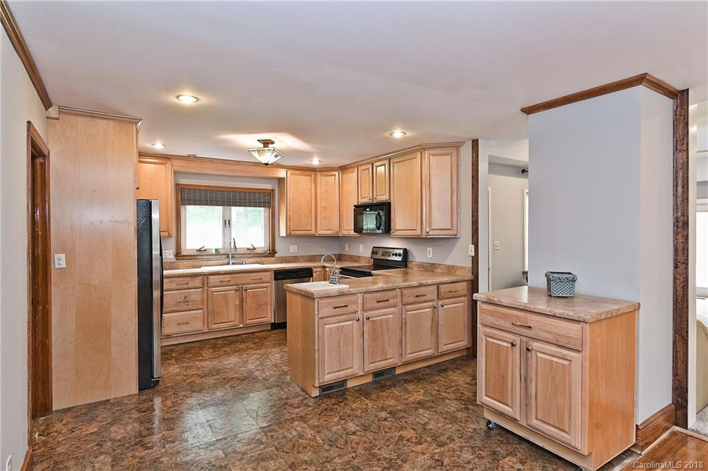 4917 Morgan Mill Road Monroe, NC 28110 - Photo 11 of 36 a kitchen with white cabinets and white appliances