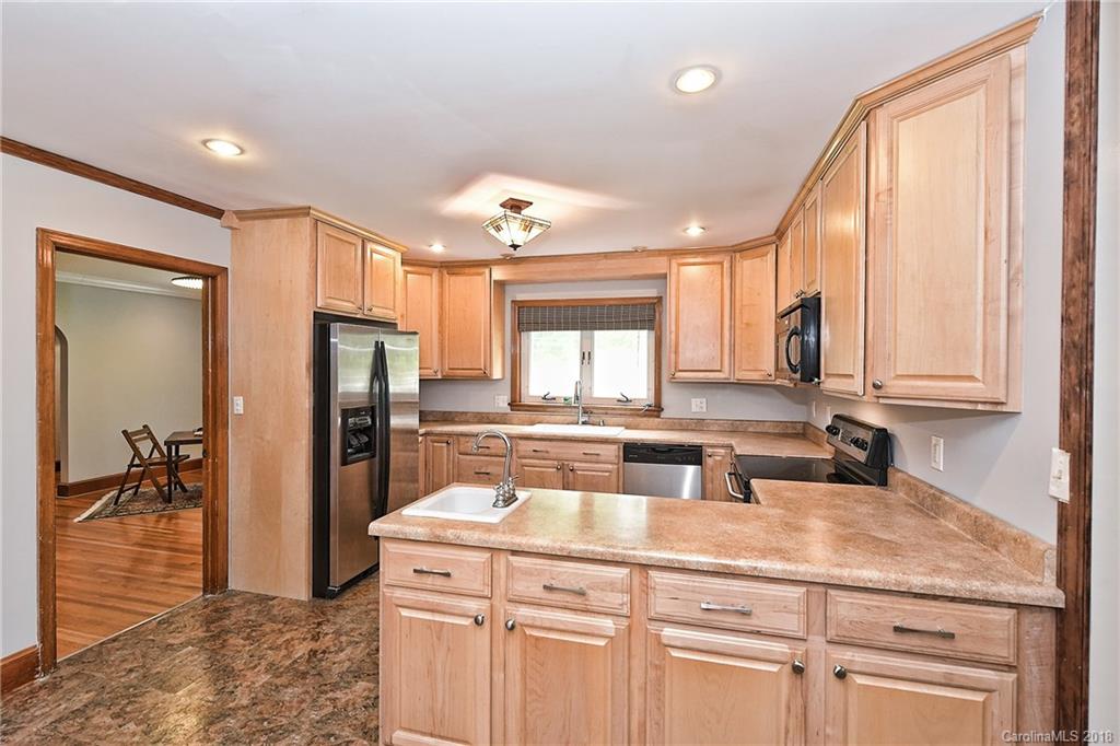 4917 Morgan Mill Road Monroe, NC 28110 - Photo 12 of 36 a kitchen with a refrigerator a sink and cabinets