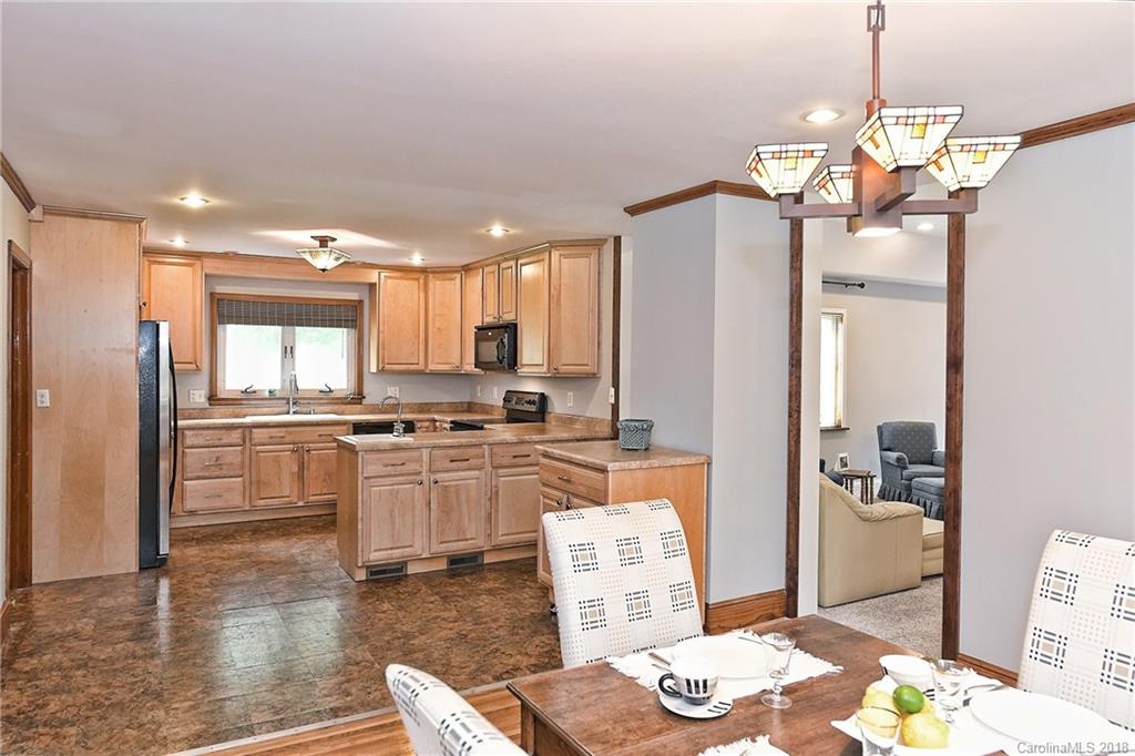 4917 Morgan Mill Road Monroe, NC 28110 - Photo 15 of 36 a kitchen with stainless steel appliances granite countertop a refrigerator a sink dishwasher a dining table and chairs with wooden floor