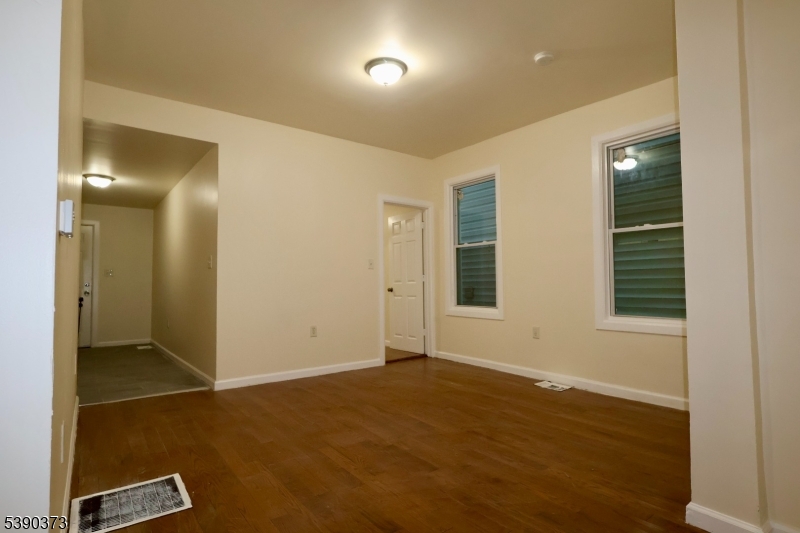 89 Cutler Street, Unit 1 Newark, NJ 07104 - Photo 3 of 13 an empty room with wooden floor and windows