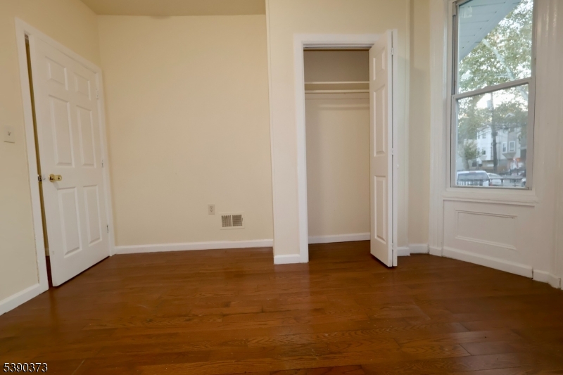 89 Cutler Street, Unit 1 Newark, NJ 07104 - Photo 8 of 13 an empty room with windows and closet