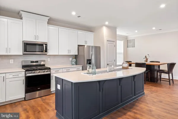 a kitchen with stainless steel appliances kitchen island granite countertop a sink stove and refrigerator