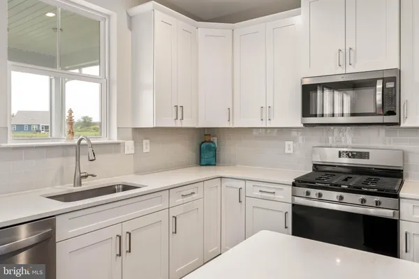 a kitchen with cabinets appliances a sink and a window