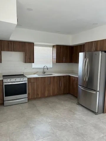 a kitchen with stainless steel appliances a refrigerator and a sink