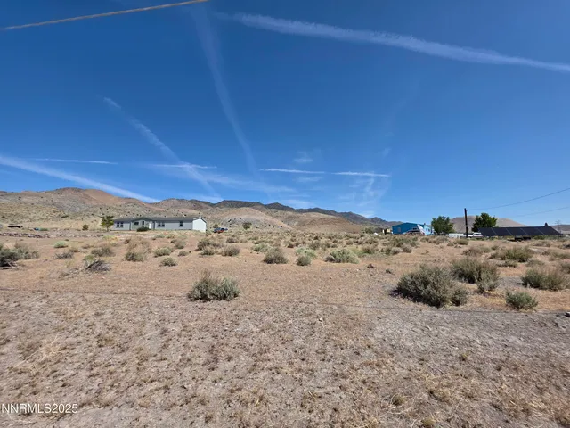 a view of a dry yard with wooden fence
