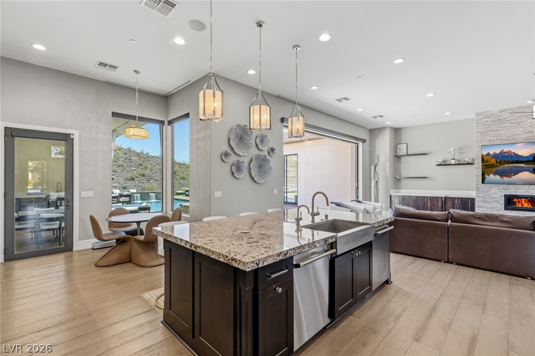 5 Crystal Tree Pass Henderson, NV 89052 - Photo 12 of 67 An open-concept living space integrates a chef's kitchen, dining area, and living room with a cozy fireplace.