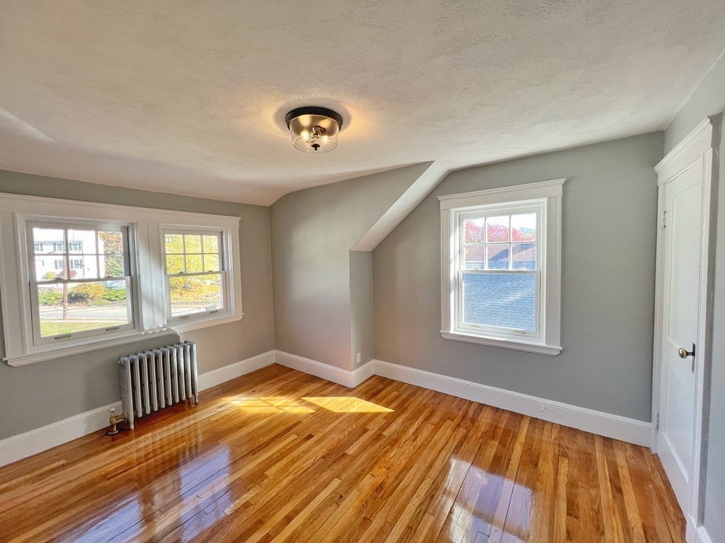 10 Governor Road Arlington, MA 02474 - Photo 18 of 22 a view of an empty room with wooden floor and a window