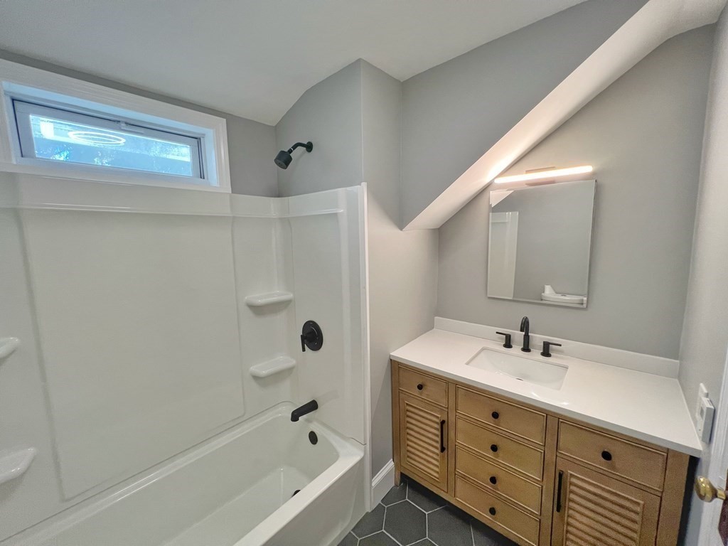 10 Governor Road Arlington, MA 02474 - Photo 20 of 22 a bathroom with a tub sink shower and mirror