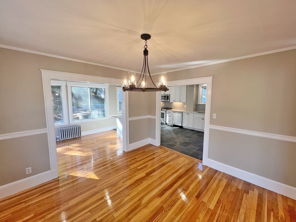 10 Governor Road Arlington, MA 02474 - Photo 6 of 22 a view of empty room with wooden floor and kitchen view