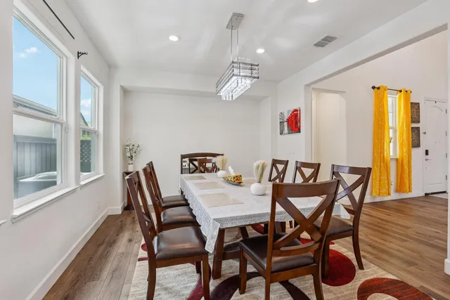 a dining room with furniture a chandelier and wooden floor